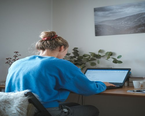 Person typing on a laptop with good posture at home